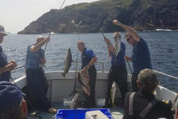 Angling_10 group of people on board holding up caught fish