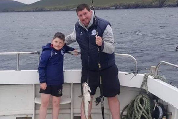 Angling_11 man and his son holding up rod with caught fish