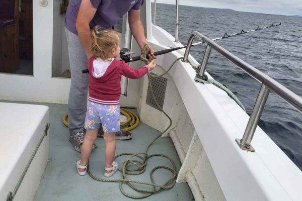 Angling_12 mean showing his young child how to hold fishing rod in the water
